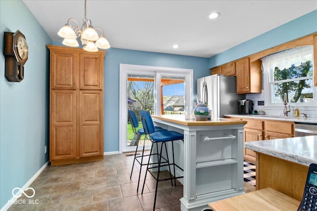 kitchen featuring stainless steel appliances, tasteful backsplash, a notable chandelier, and baseboards