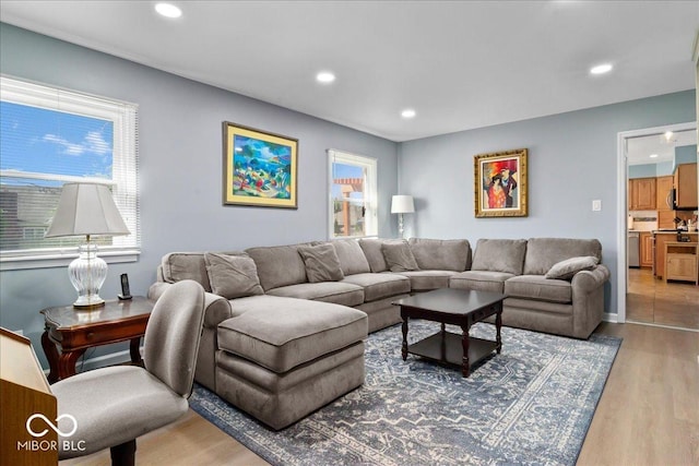 living area with light wood-type flooring and recessed lighting