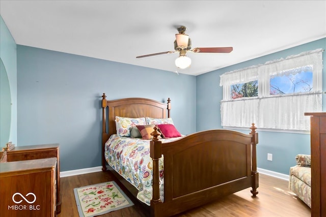 bedroom with baseboards, a ceiling fan, and wood finished floors