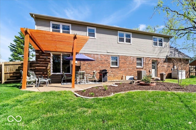 back of property with brick siding, fence, a patio, and a yard