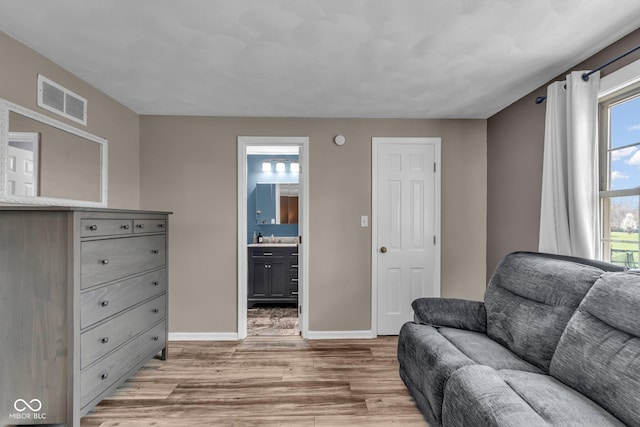 sitting room with visible vents, baseboards, and light wood-style floors