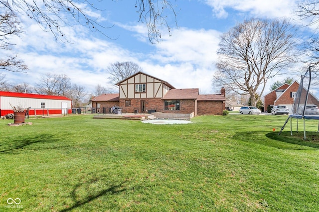 back of property with a yard and brick siding