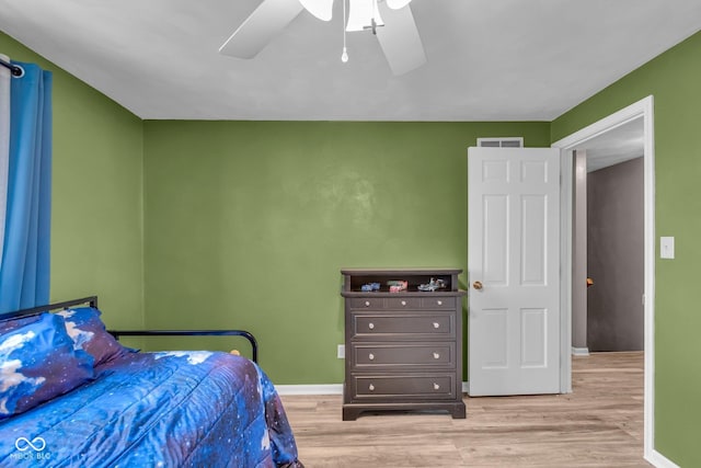bedroom with visible vents, baseboards, ceiling fan, and light wood-style floors