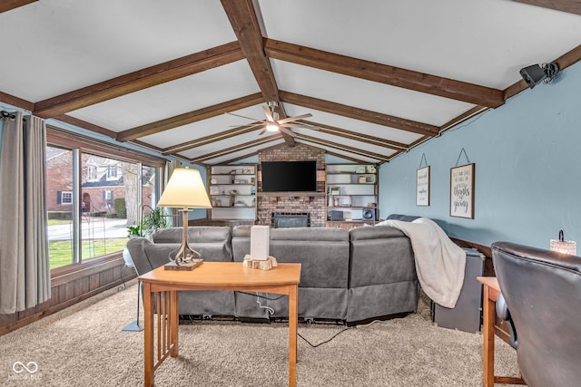 living area featuring vaulted ceiling with beams, a ceiling fan, carpet, and a brick fireplace