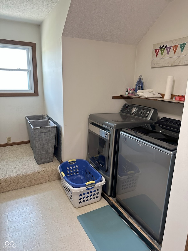 clothes washing area with washer and dryer, carpet, laundry area, and a textured ceiling