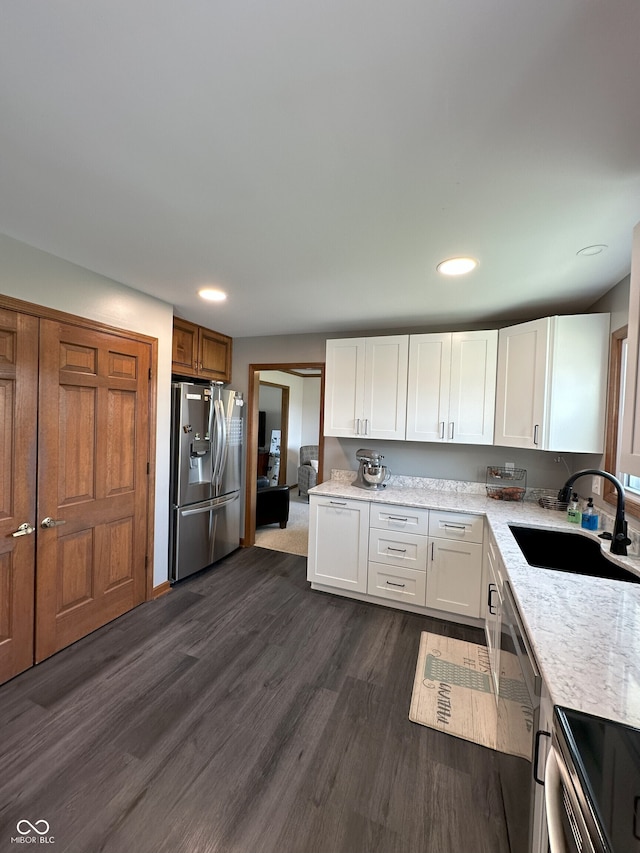 kitchen featuring dark wood finished floors, white cabinetry, recessed lighting, appliances with stainless steel finishes, and a sink