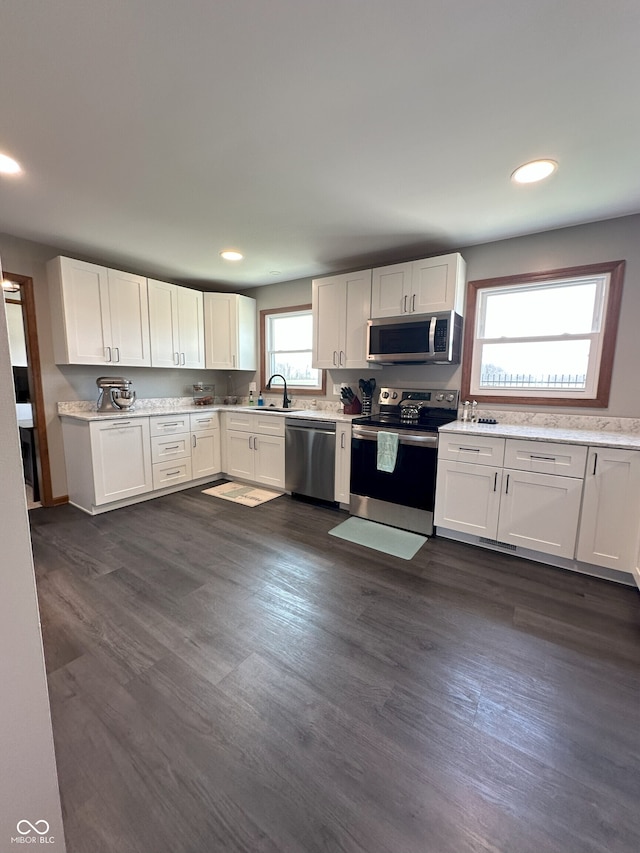 kitchen with dark wood-style flooring, recessed lighting, white cabinets, appliances with stainless steel finishes, and a sink