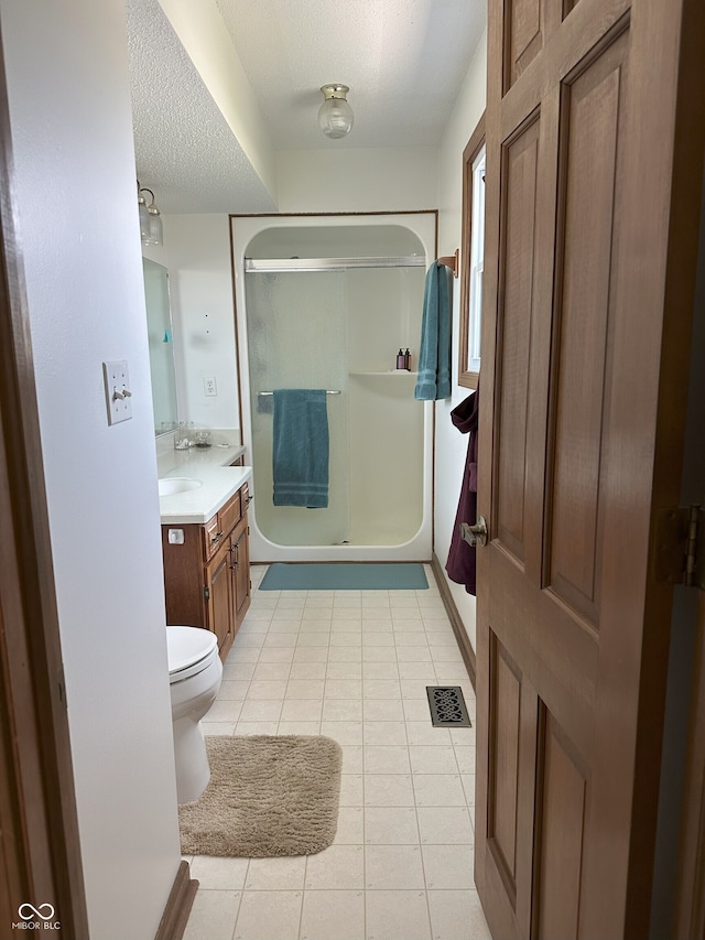 full bathroom featuring vanity, tile patterned floors, an enclosed shower, a textured ceiling, and visible vents