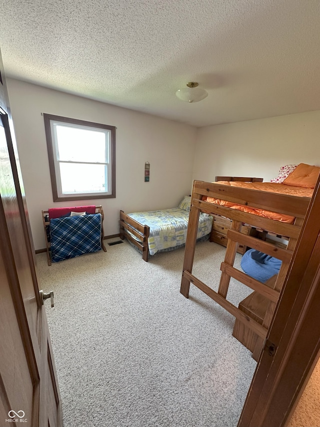 carpeted bedroom featuring a textured ceiling