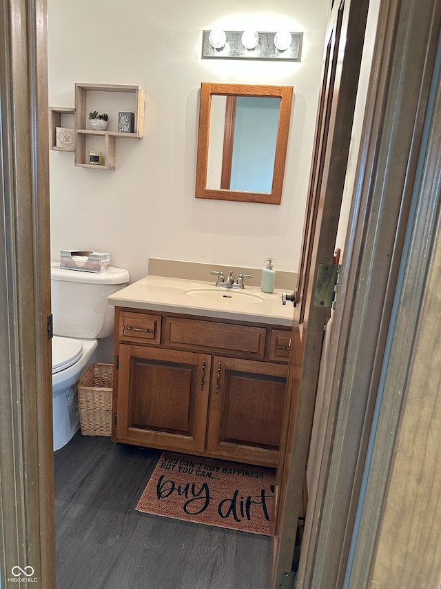 bathroom featuring toilet, wood finished floors, and vanity