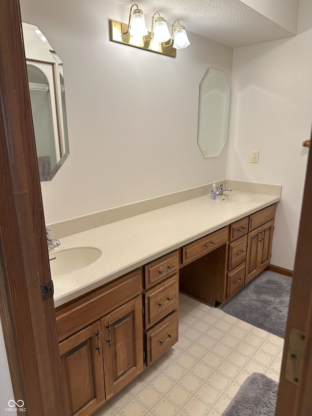 full bath featuring tile patterned floors, double vanity, a textured ceiling, and a sink