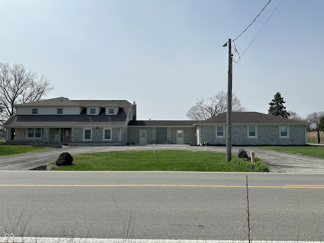 view of property featuring a front yard and stone siding