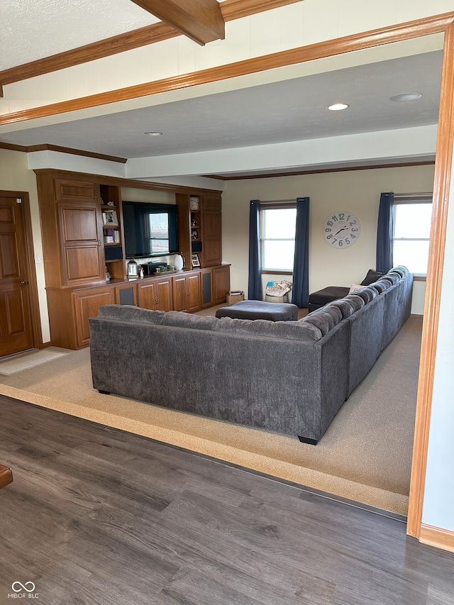 living room with recessed lighting, crown molding, beam ceiling, and wood finished floors