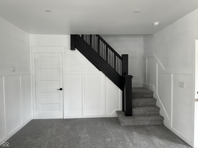 stairway with a decorative wall and carpet