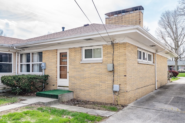 exterior space with a chimney and brick siding