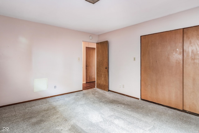 unfurnished bedroom with a closet, baseboards, and carpet flooring