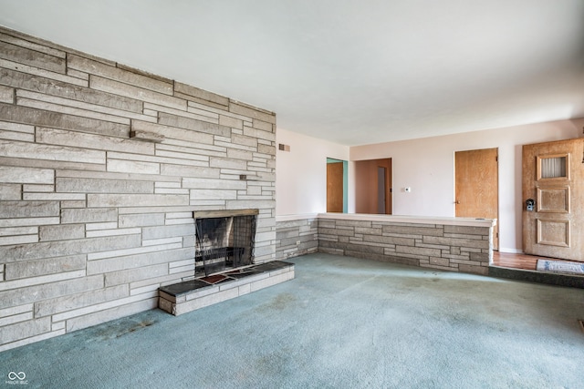 unfurnished living room with carpet, visible vents, and a stone fireplace