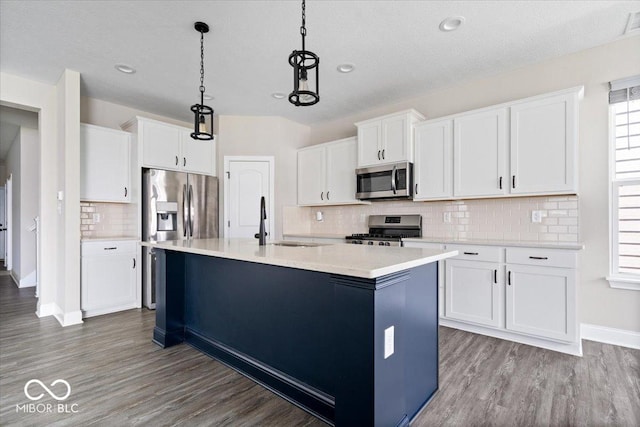 7012 Pickett Pl, Carmel, IN 46033 - kitchen featuring appliances with stainless steel finishes, a sink, wood finished floors, light countertops, and decorative light fixtures
