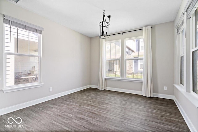 7012 Pickett Pl, Carmel, IN 46033 - empty room featuring dark wood finished floors, baseboards, and a chandelier