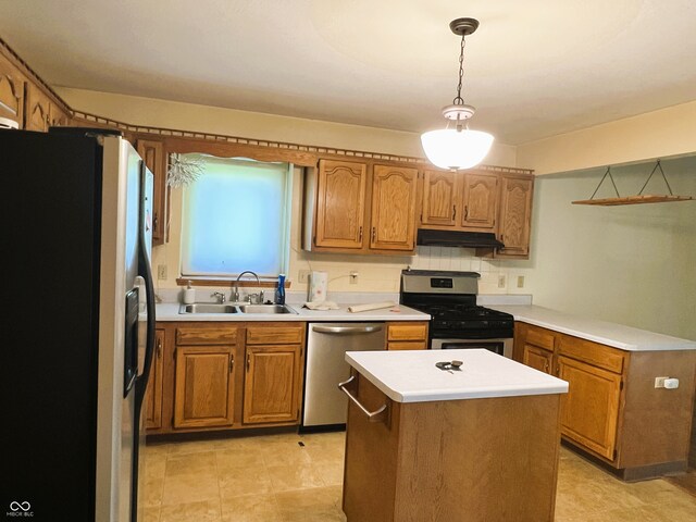 8809 Jonathon Pl, New Haven, IN 46774 - kitchen featuring appliances with stainless steel finishes, a sink, under cabinet range hood, brown cabinetry, and light countertops