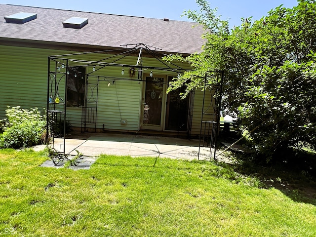 8809 Jonathon Pl, New Haven, IN 46774 - rear view of house featuring roof with shingles, a lawn, and a patio
