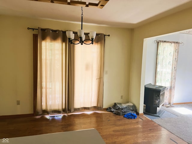 8809 Jonathon Pl, New Haven, IN 46774 - unfurnished dining area featuring a chandelier, wood finished floors, and a wood stove