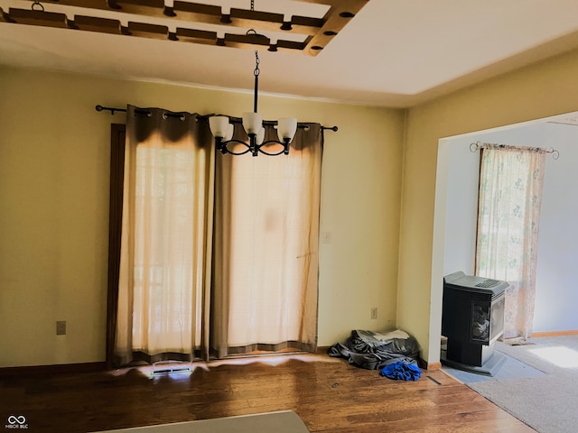8809 Jonathon Pl, New Haven, IN 46774 - unfurnished dining area with a wood stove, dark wood-style flooring, and a chandelier
