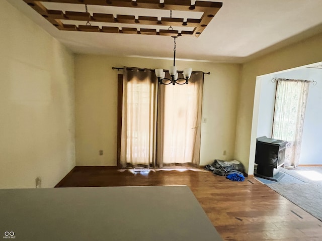 8809 Jonathon Pl, New Haven, IN 46774 - unfurnished dining area with a chandelier, a wood stove, and wood finished floors