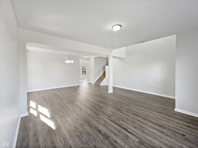8251 Garden Ridge Rd, Indianapolis, IN 46237 - unfurnished living room featuring baseboards, stairs, a notable chandelier, and dark wood finished floors