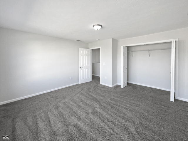 8251 Garden Ridge Rd, Indianapolis, IN 46237 - unfurnished bedroom featuring dark carpet, baseboards, and a closet