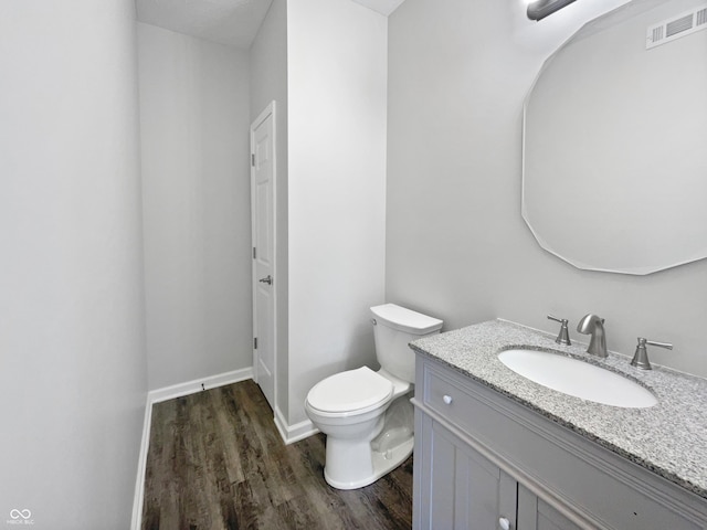 8251 Garden Ridge Rd, Indianapolis, IN 46237 - bathroom with vanity, visible vents, toilet, wood finished floors, and baseboards