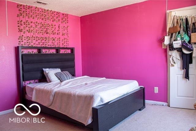 10105 Yosemite Ln, Indianapolis, IN 46234 - carpeted bedroom featuring visible vents, a textured ceiling, and baseboards