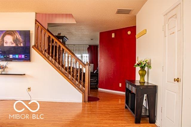 10105 Yosemite Ln, Indianapolis, IN 46234 - stairway with visible vents, baseboards, wood finished floors, and a textured ceiling