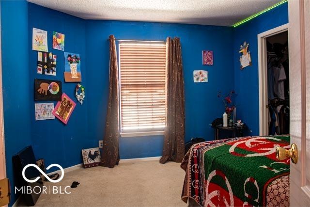 10105 Yosemite Ln, Indianapolis, IN 46234 - carpeted bedroom with a textured ceiling and baseboards