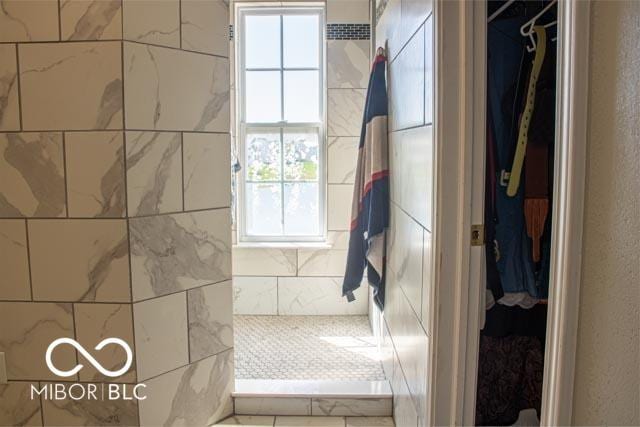 10105 Yosemite Ln, Indianapolis, IN 46234 - bathroom with a walk in closet, tiled shower, and a textured wall