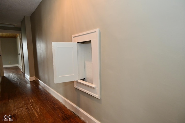 hallway featuring baseboards and dark wood finished floors