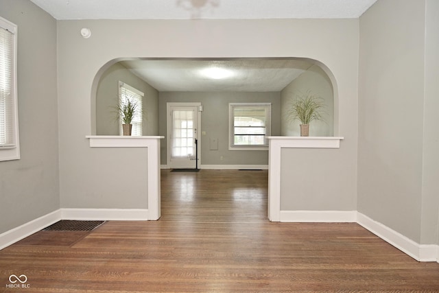 foyer entrance featuring visible vents, baseboards, and wood finished floors