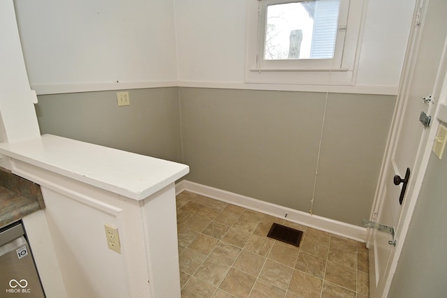 clothes washing area featuring visible vents and baseboards