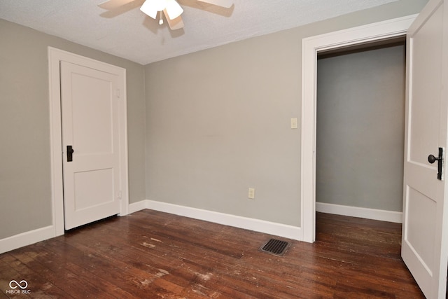unfurnished bedroom featuring visible vents, baseboards, a ceiling fan, and hardwood / wood-style flooring