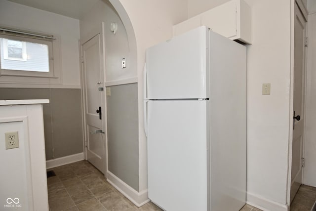 kitchen with white cabinets and freestanding refrigerator