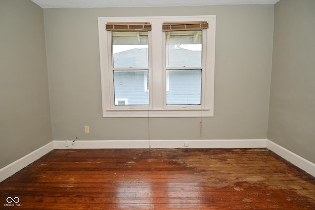 spare room featuring wood finished floors and baseboards