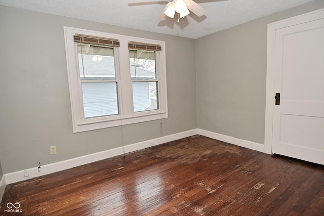 empty room featuring dark wood-type flooring, baseboards, and ceiling fan