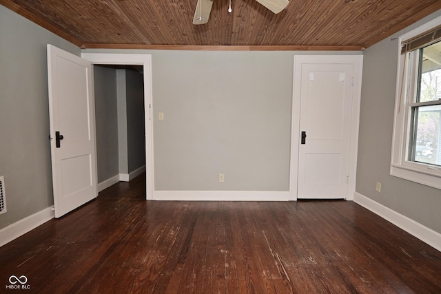 empty room with wood ceiling, wood-type flooring, a ceiling fan, and baseboards