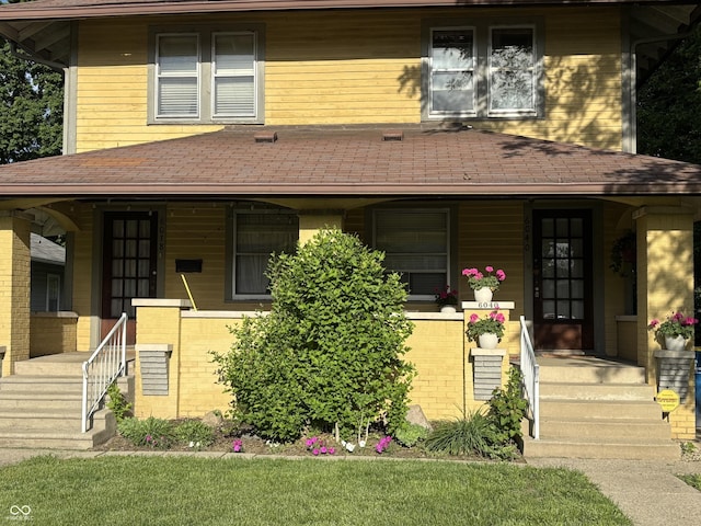 6038 N College Ave, Indianapolis, IN 46220 - view of front of house featuring covered porch, brick siding, and roof with shingles