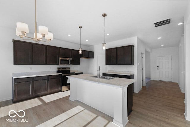 1117 Stubble Run, Danville, IN 46122 - kitchen with stainless steel appliances, light wood finished floors, light countertops, a chandelier, and dark brown cabinetry