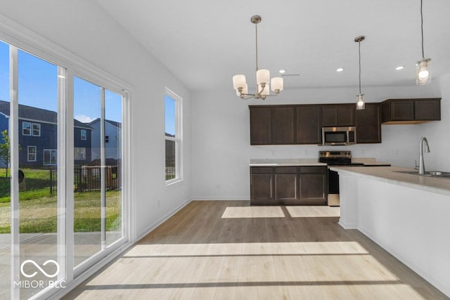 1117 Stubble Run, Danville, IN 46122 - kitchen featuring appliances with stainless steel finishes, light wood-style flooring, dark brown cabinets, hanging light fixtures, and recessed lighting