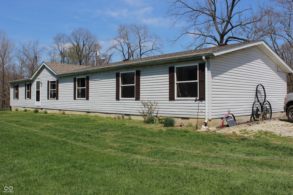 view of property exterior featuring a shingled roof, crawl space, and a lawn