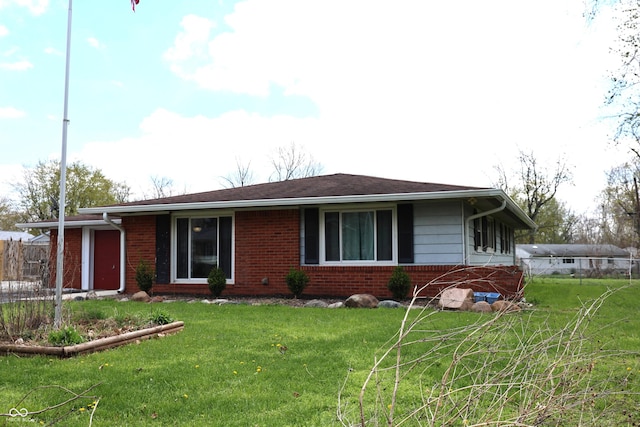 view of front of home featuring a front yard and brick siding