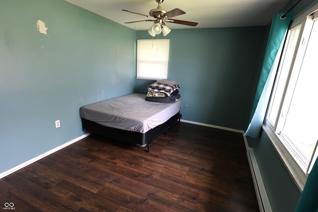 bedroom with baseboards, a ceiling fan, wood finished floors, and baseboard heating