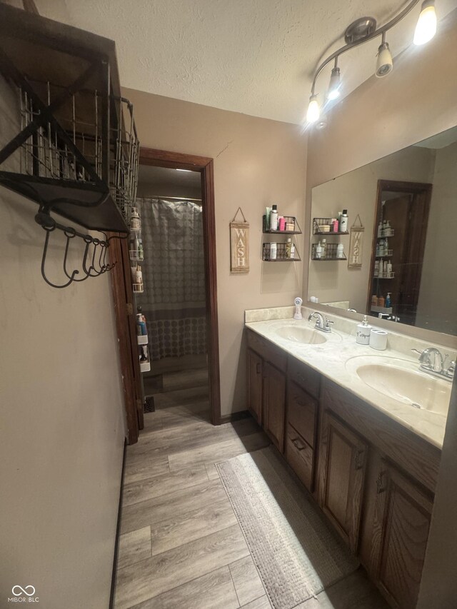 474 Mill, Coatesville, IN 46121 - full bath featuring double vanity, wood finished floors, a textured ceiling, and a shower with shower curtain